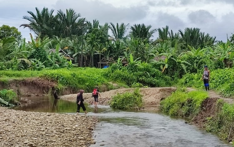 warga Buttui menyeberangi sungai 